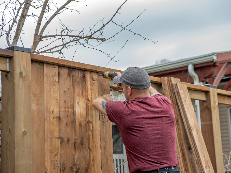 Professional contractor installing a custom cedar wood privacy fence for a residential property in Burlington.