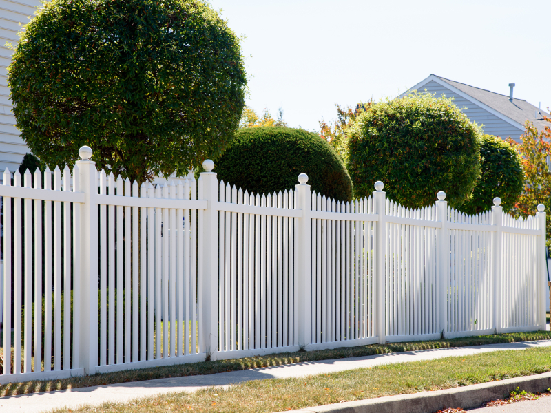 White vinyl picket fence with decorative post caps installed on a residential property in the Greater Toronto Area (GTA) by King Fence.